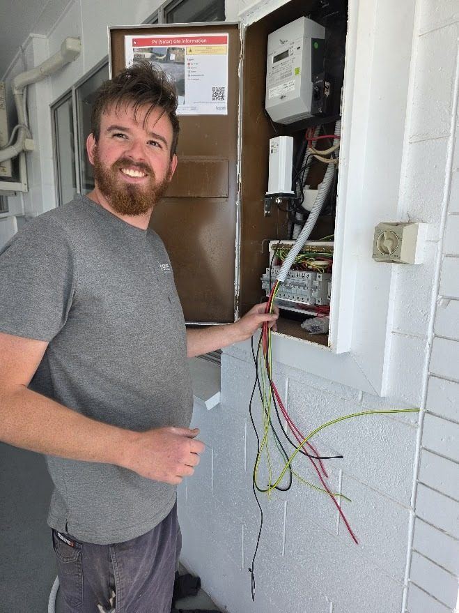 In Series electrician wiring up a solar switchboard on site
