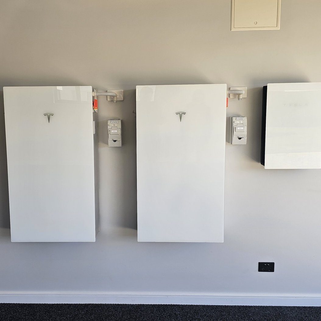 Two Tesla Powerwall battery units and a Tesla gateway wall-mounted in a Tasmanian home
